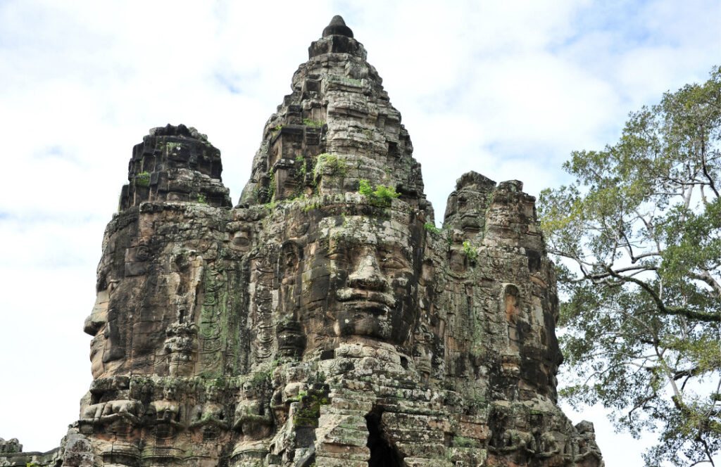 Um rosto esculpido em um grande morro de pedras, em Angkor Wat