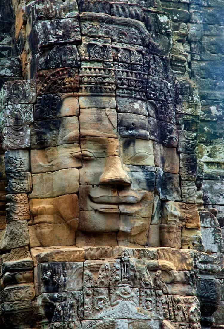 um rosto com sorriso, esculpido em uma montanha de pedras, gigante parecendo um quebra cabeças.