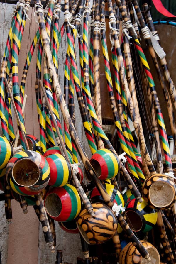 vários berimbaus, um ao lado do outro, todos bem coloridos pendurados em uma parede na cidade de Salvador