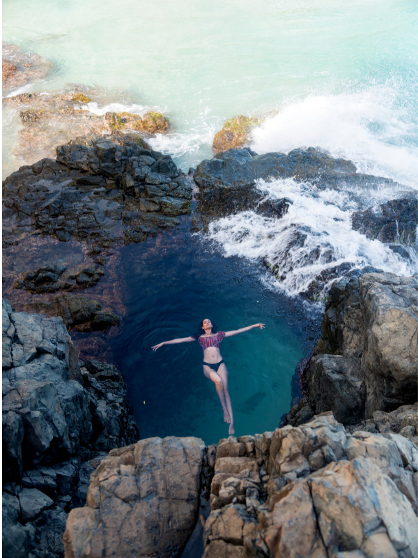 mulher nadando em uma piscina natural em meio de rochas no mar em Fernando de Noronha